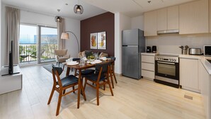 Eine moderne Küche mit Essbereich, mit großem Fenster und schöner Aussicht, inklusive Einbauofen und Kühlschrank.