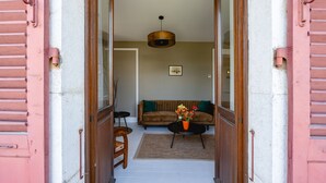 An open doorway leading to a living room with a sofa, a coffee table, and a hanging light fixture. - Le Paradis - Beautiful T3 with nice view on the Visitation (Annecy)