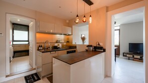 A modern kitchen with a central island, built-in appliances, and pendant lighting. - Le Paradis - Beautiful T3 with nice view on the Visitation (Annecy)