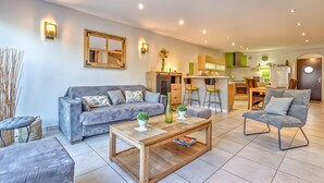 A modern living room with a grey sofa, a wooden coffee table, and a grey armchair. - Les Terrasses de Bredanne (Doussard)