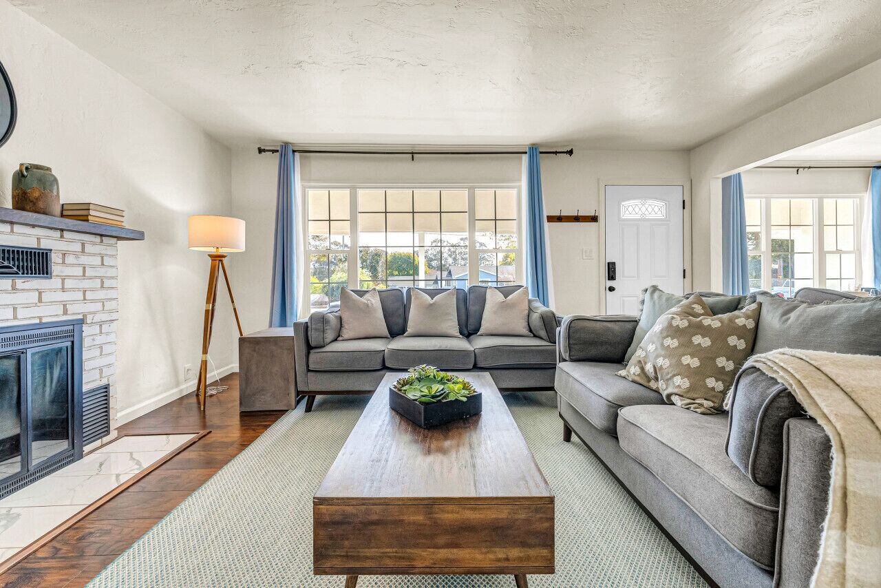 A living room with a fireplace, two sofas, a coffee table, and a lamp.
