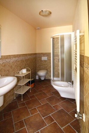 Ein Badezimmer mit zwei Waschbecken, einer Toilette und einer Dusche.