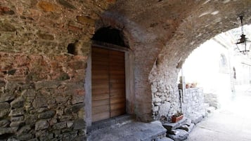 Un edificio de piedra con una puerta de madera bajo un arco de piedra.