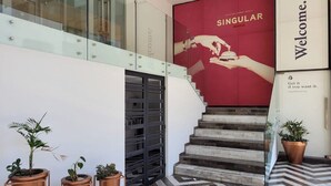 Ein Hotel Eingangsbereich mit Treppe, Blumentöpfen und einem 'Welcome'-Schild.