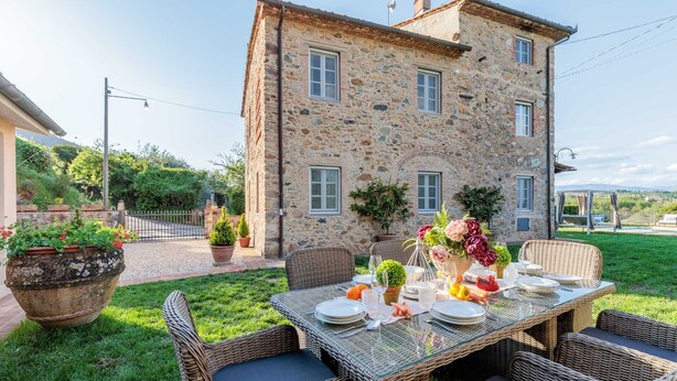 A stone building with a dining area set up outside. - Villa Aperitivo, Romantic and Panoramic Stone Farmhouse with Private Swimming Pool on the Hills of Lucca close to Lucca, Pisa and the Compitese area (Pieve di Compito)
