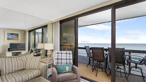 A balcony with a view of the sea, furnished with a sofa, armchairs, and a table. - Golden Sands 912 by Seaside Vacations & Sales (Ocean City)