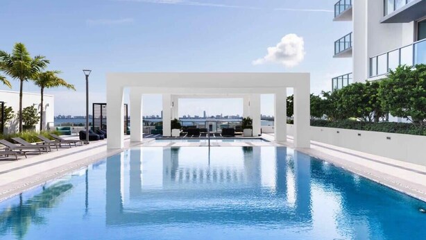 A modern swimming pool with a clear view of the city skyline in the background.