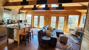A cabin interior with a kitchen, dining area, and living room. - The Hideaway Spot- Waterfront w/ Dock on Long Cove (Glen Burnie)