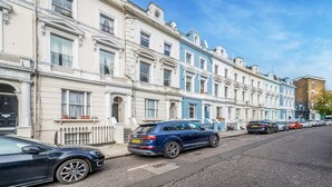 A row of terraced houses with a parked car in front. - Cozy, cute flat in Notting Hill - Pass the Keys (London)
