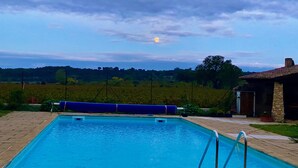 A rectangular swimming pool with a blue border, surrounded by stone tiles. - Mastignac (Valreas)