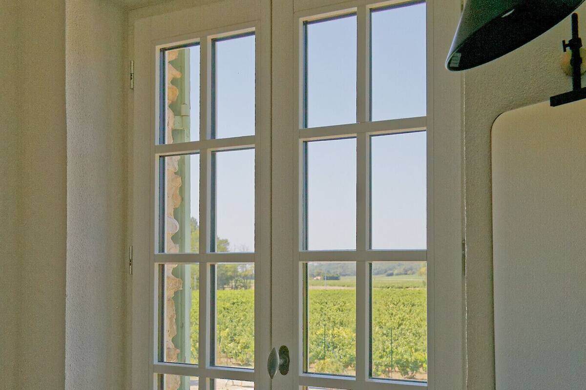 A bathroom with a white sink, a window, and a view of a swimming pool.