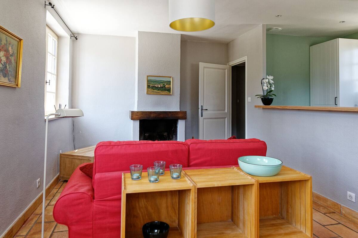 A living room with a red sofa, a wooden coffee table with glasses, and a white door.