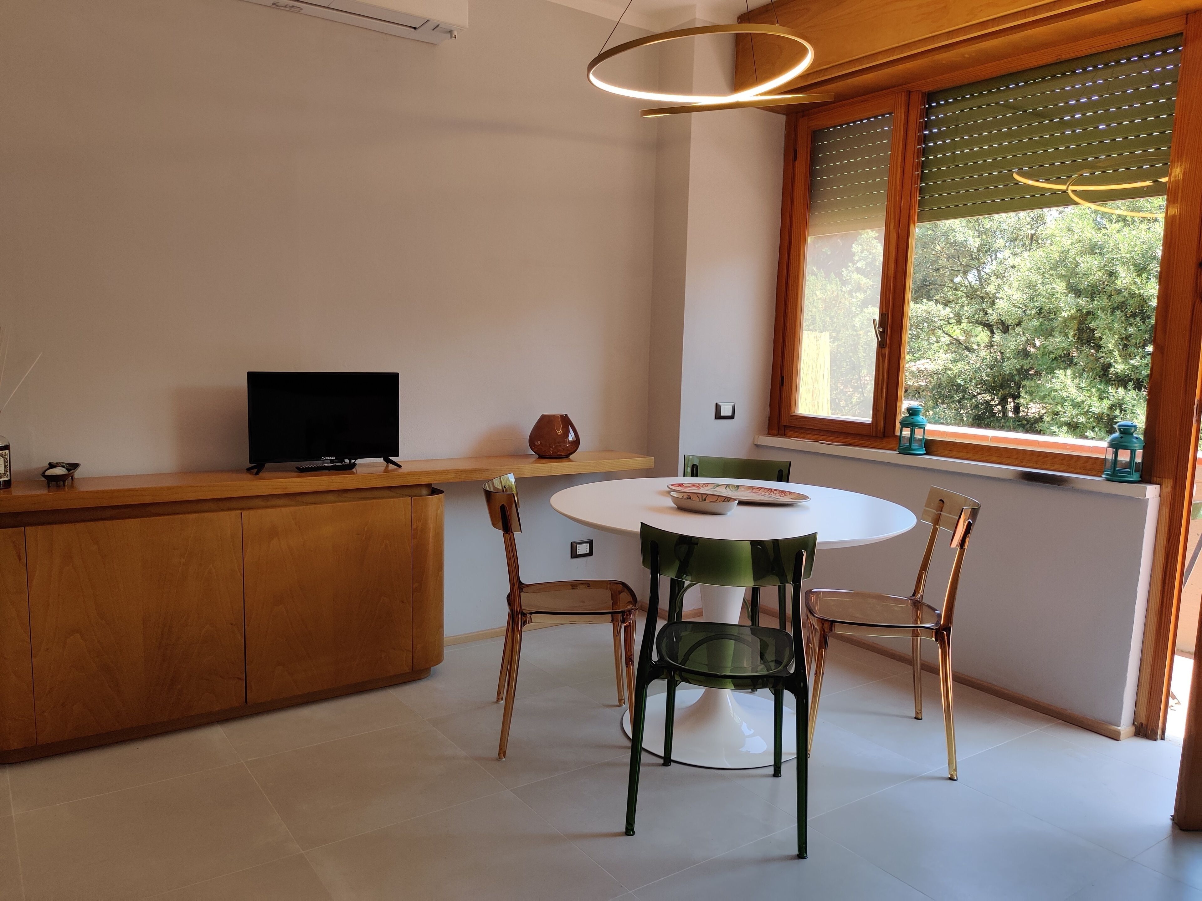 A modern kitchen with a wooden counter, a round dining table, and chairs.