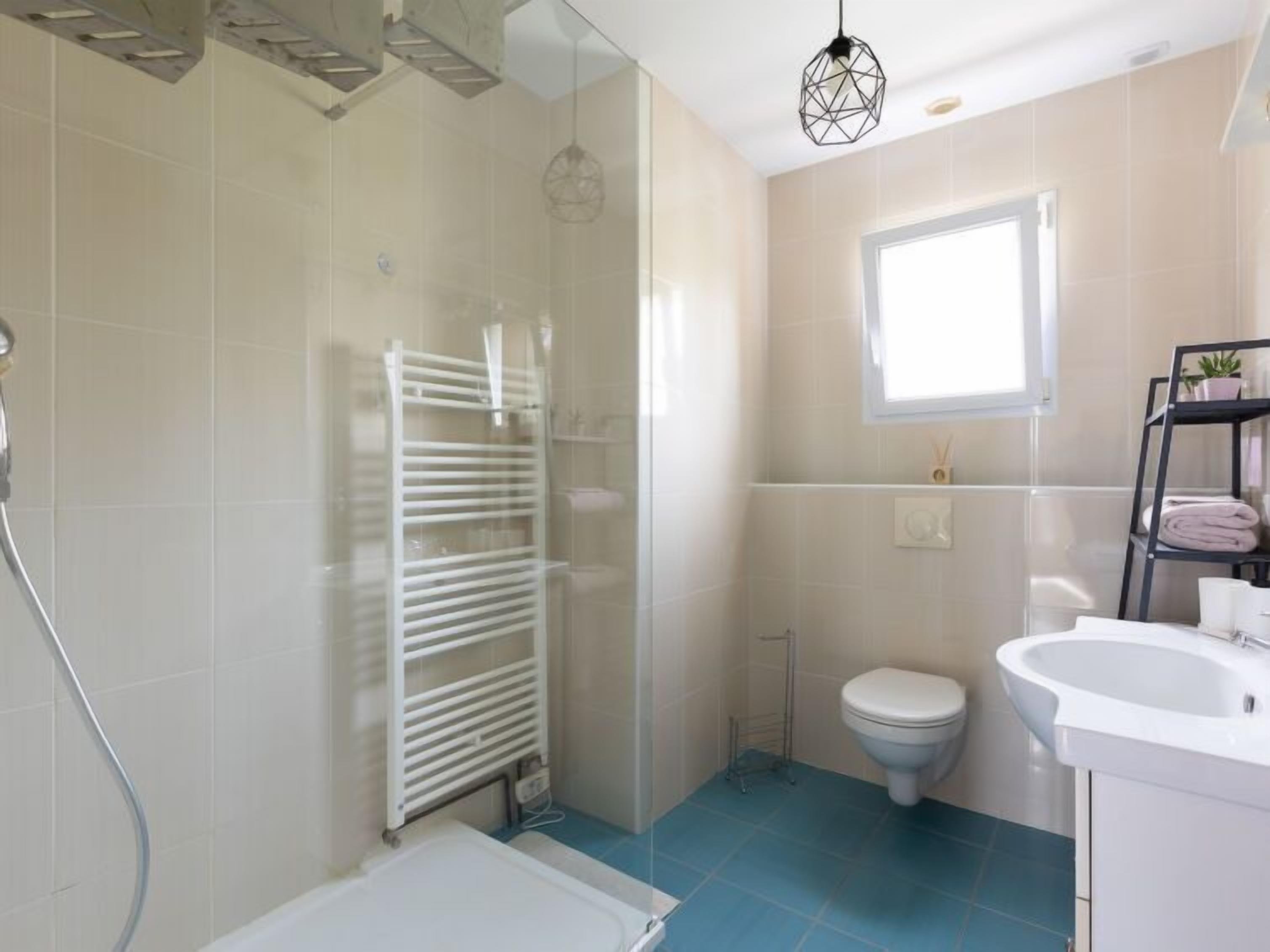 Une salle de bain avec douche, toilettes et lavabo.