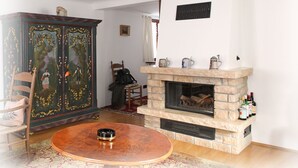 Un salon avec une cheminée, une table en bois et un meuble décoratif.
