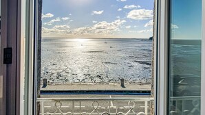 A view from a window overlooking a beach with the ocean and a clear sky. - L'Emeraude by Interhome (Cancale)