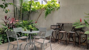 Un patio al aire libre con una mesa redonda y sillas, una bicicleta y varias plantas.