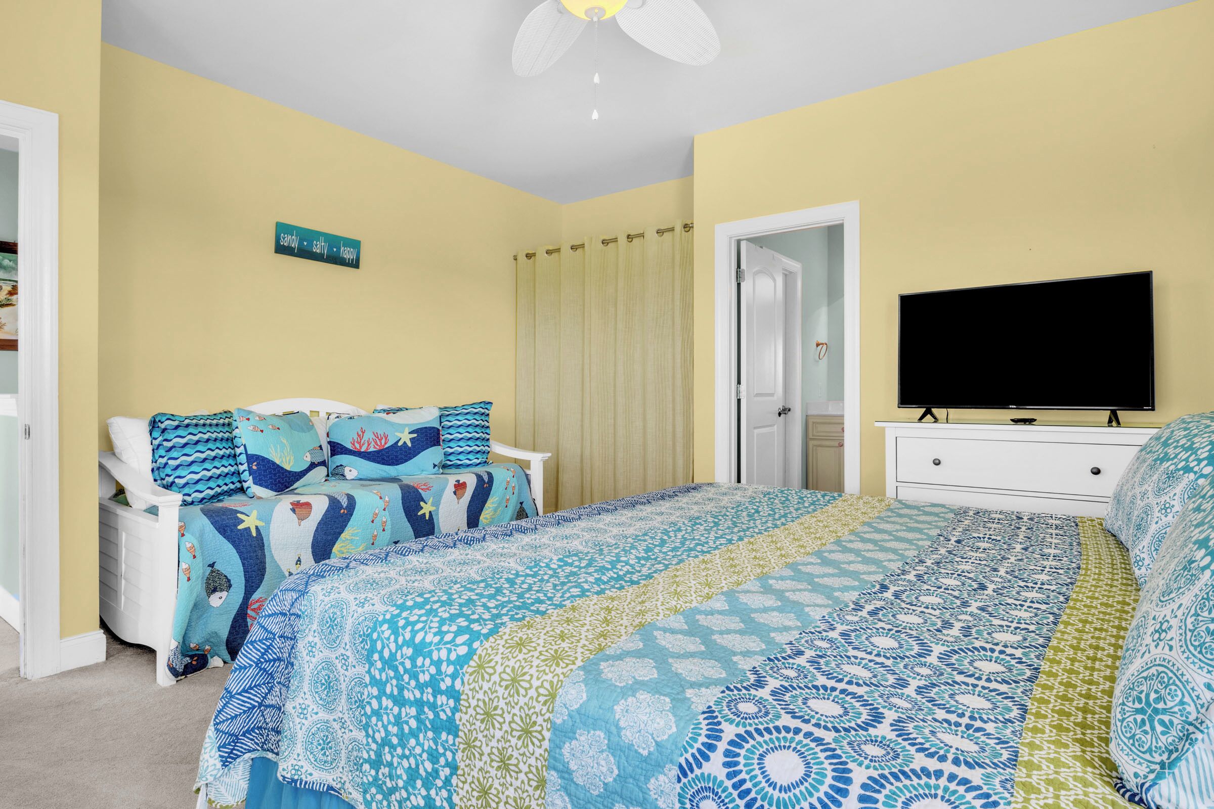 A bedroom with a bed, a TV, and a window.