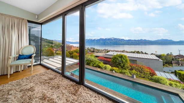 A room with a large window overlooking a swimming pool and a mountainous landscape. - Best Villa with Pool & Panoramic views (Lutry)