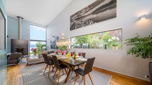 A modern dining area with a large window, a fireplace, and a dining table set for six. - Best Villa with Pool & Panoramic views (Lutry)