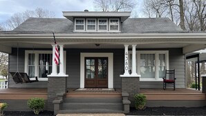 A two-story house with a front porch, a mailbox, and a small garden area. - The Gray House (Paducah)