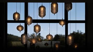 A series of hanging lanterns in a room with large windows.