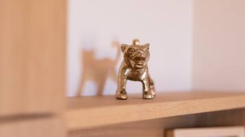 Uma pequena figura dourada de um urso em uma prateleira de madeira.