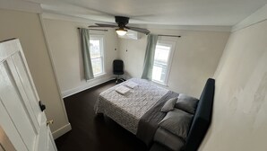 A bedroom with a bed, a ceiling fan, and two windows with curtains. - Charming 4 BD near DT Geneva (Geneva)