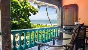 A balcony with a view of the ocean, a chair, and a table. - Casa de Playa - Playa Hermosa Jaco (Jacó)