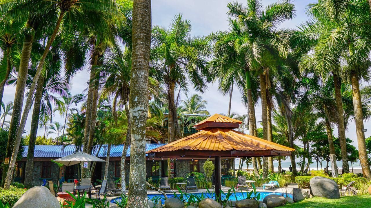 Ein Resort mit Pool, Liegestühlen und einer Laube.