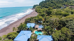 An aerial view of a coastal resort with a beach, palm trees, and a swimming pool. - Casa de Playa - Playa Hermosa Jaco (Jacó)