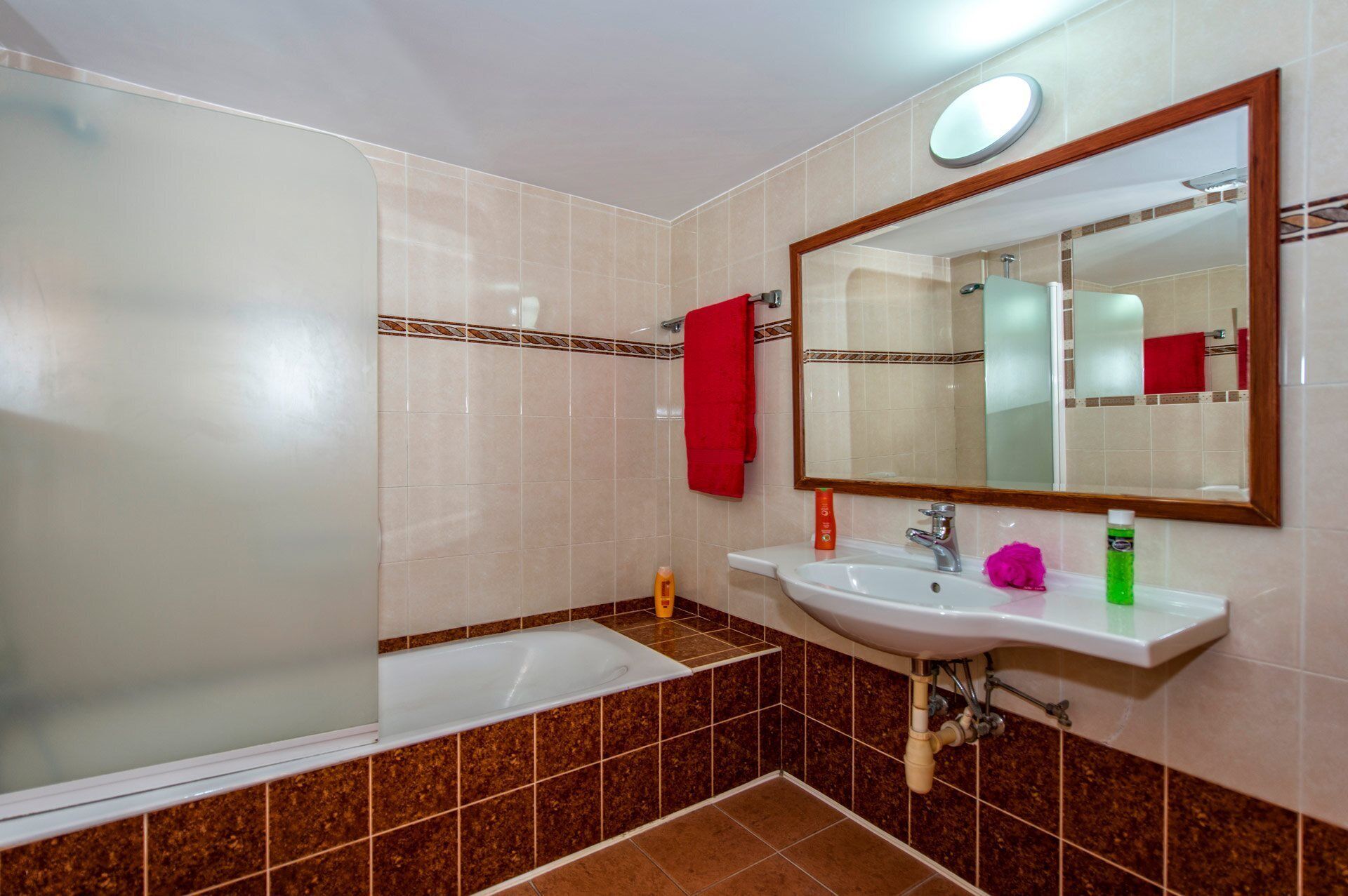 A bathroom with a bathtub, a sink, and a mirror.