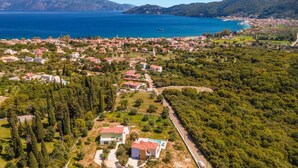 Une vue aérienne d’une ville côtière, avec des maisons, une route et une étendue d’eau.