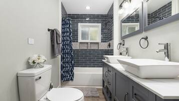 Bathtub, hair dryer, towels, shampoo