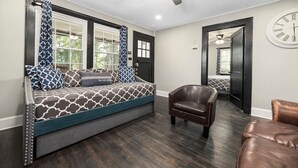 A cozy room with a built-in bench, a leather armchair, and a large wall clock. - "Mt. Holly Haven" — Near Whitewater Center, Belmont Abbey, Catawba River, CLT (Mount Holly)