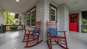 A porch with two rocking chairs, a red door, and a white exterior wall. - "Mt. Holly Haven" — Near Whitewater Center, Belmont Abbey, Catawba River, CLT (Mount Holly)