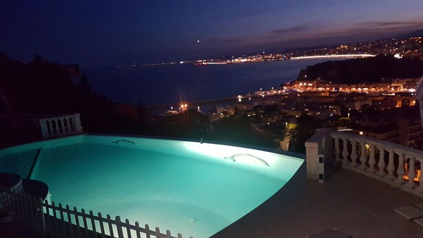 Una piscina amb vistes a un paisatge urbà al capvespre.