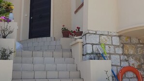 Un edifici amb façana corbada, una porta negra i un conjunt d'escales de pedra que condueixen a l'entrada.