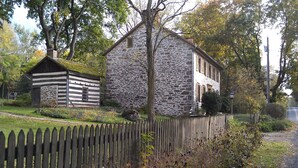 Edifici de pedra amb una tanca de fusta al davant.