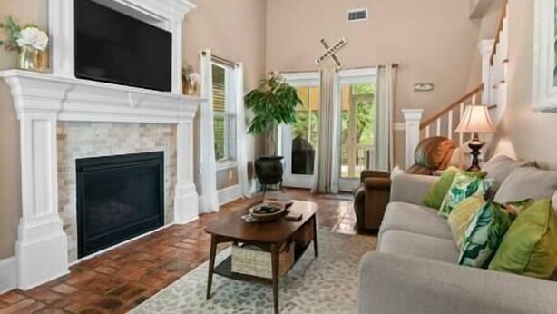 A spacious living room with a fireplace, a television, a sofa, and a coffee table.