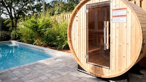 A wooden sauna structure with a glass door, adjacent to a swimming pool. - Church St Collection - 106 (Fairhope)
