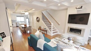 A modern living room with a sofa, a coffee table, and a TV mounted on the wall. - The Hip Strip - Stroll to Columbia Heights (Washington)
