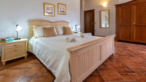 Una camera da letto con un letto, comodini, un armadio e un condizionatore d'aria a parete.