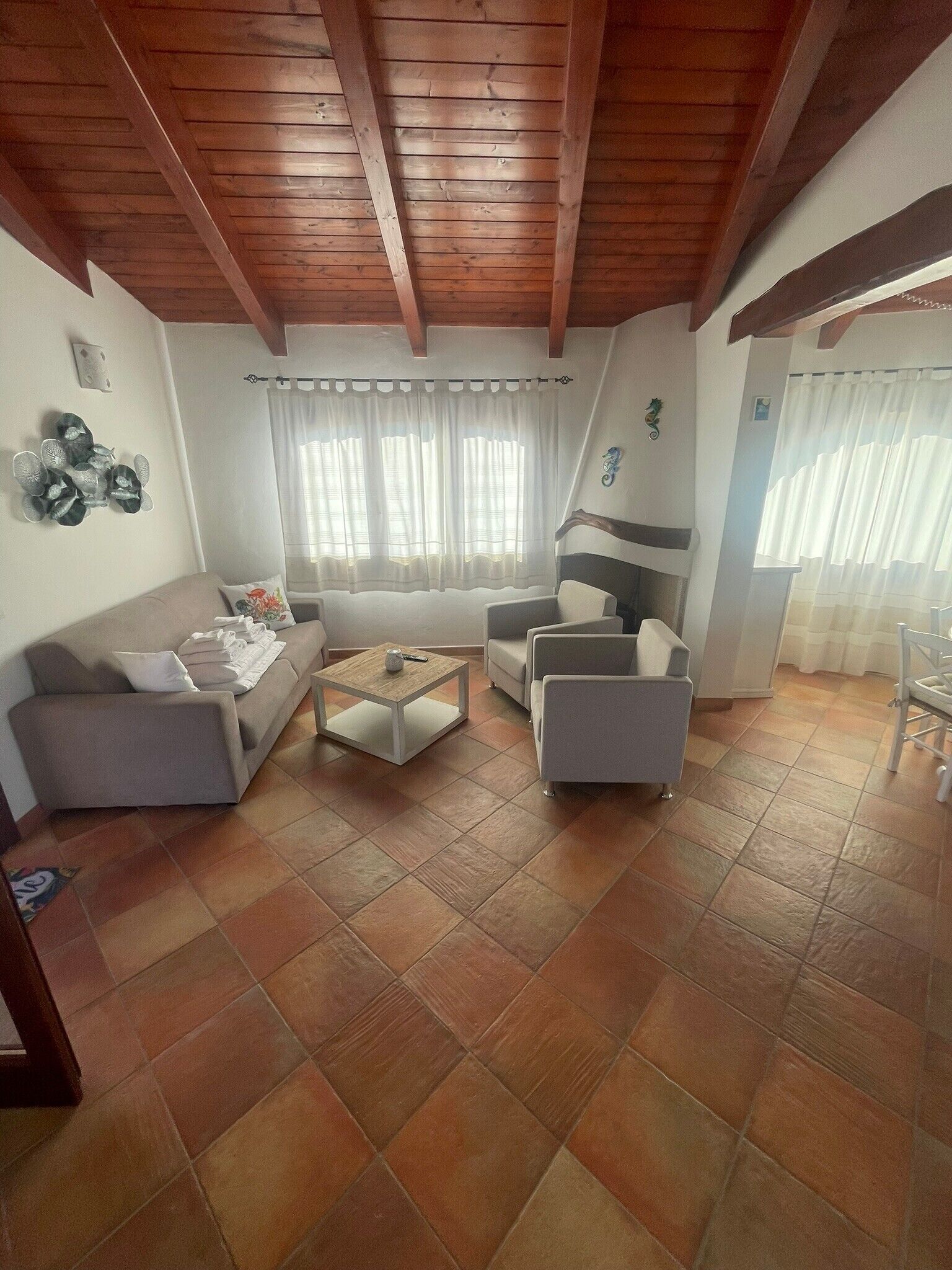 A living room with a sofa, armchairs, a coffee table, and a fireplace.