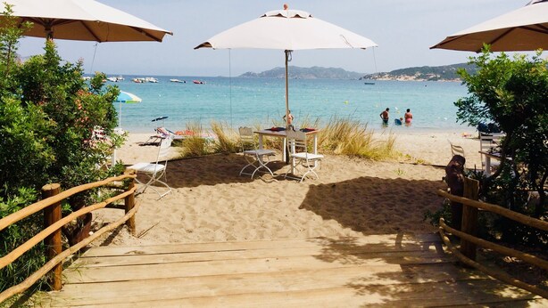 A wooden staircase leading to a beach with umbrellas and chairs. - Apartment Runcina 1 with Sea View, Wi-Fi and Shared Pool (San Teodoro)