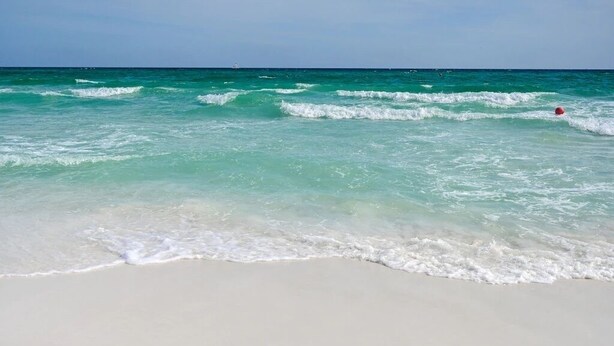 A beach with clear turquoise water and white sand.