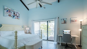 A bedroom with a bed, a desk, and a computer.