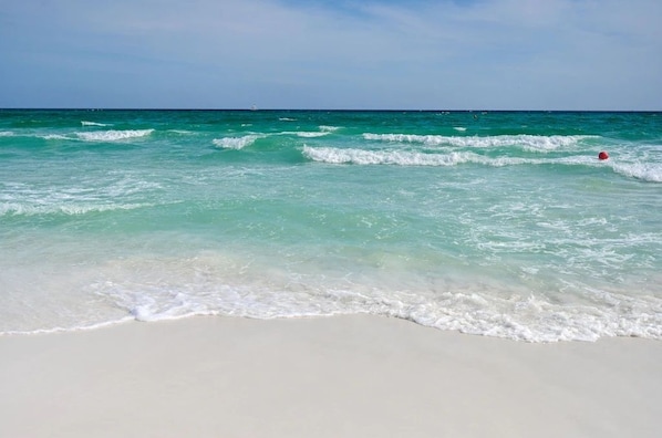 Uma praia com águas turquesa cristalinas e areia branca.