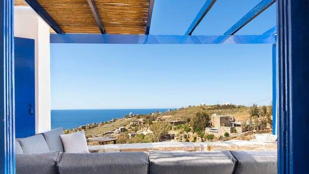 A balcony with a view of a coastal village and the sea.