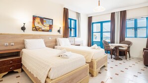A hotel room with two beds, a desk, and a chair. - Holiday Home 'Livadia Beach Tilos Apartment ' with Sea View, Wi-Fi and Air Conditioning (tilos)